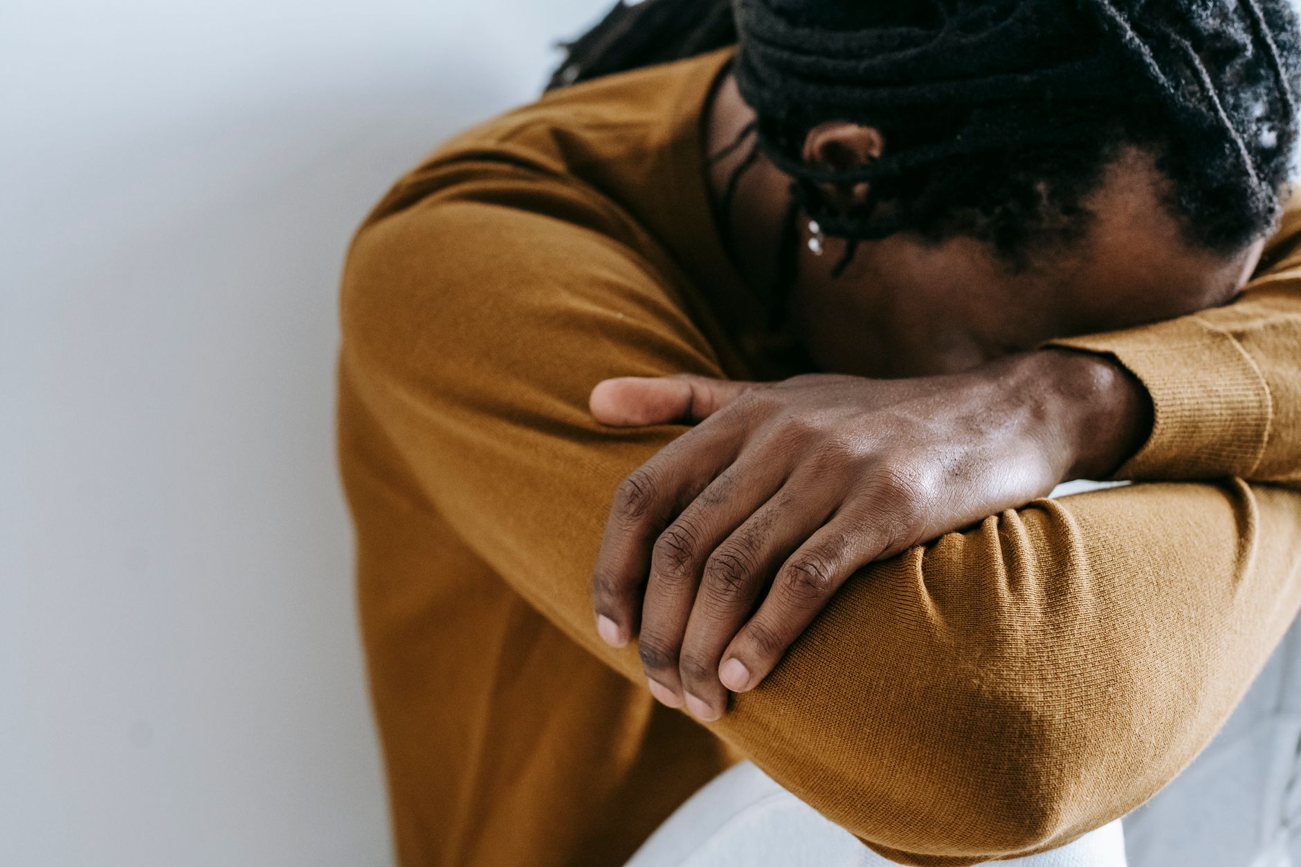 unrecognizable desperate black man on light background