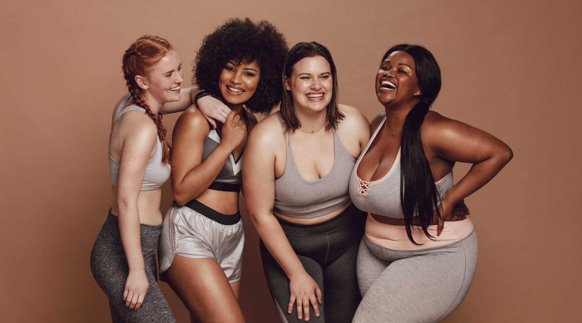 4 multiracial women of different sizes in fitness clothes