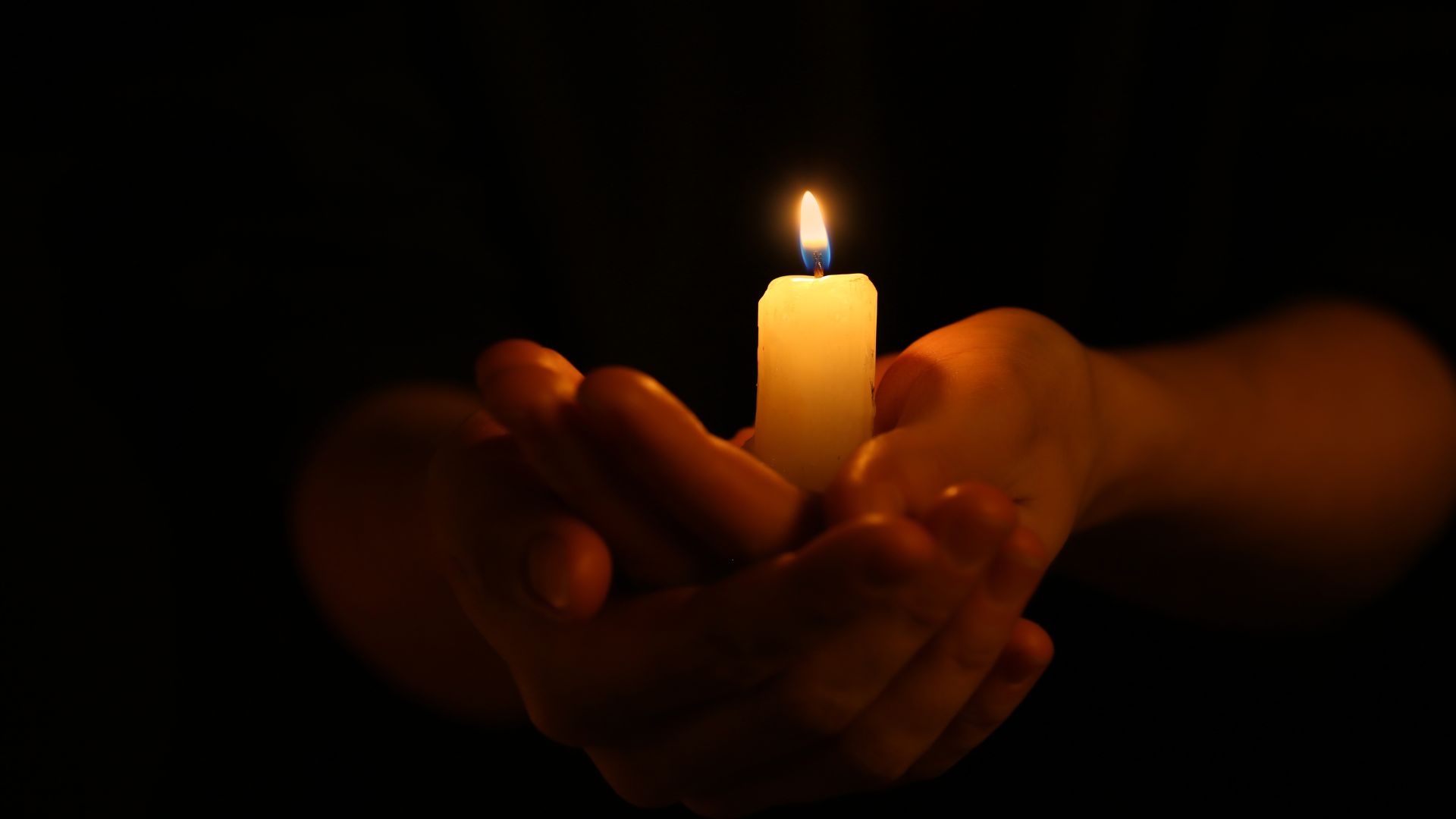 hands holding candle bipoc death doula