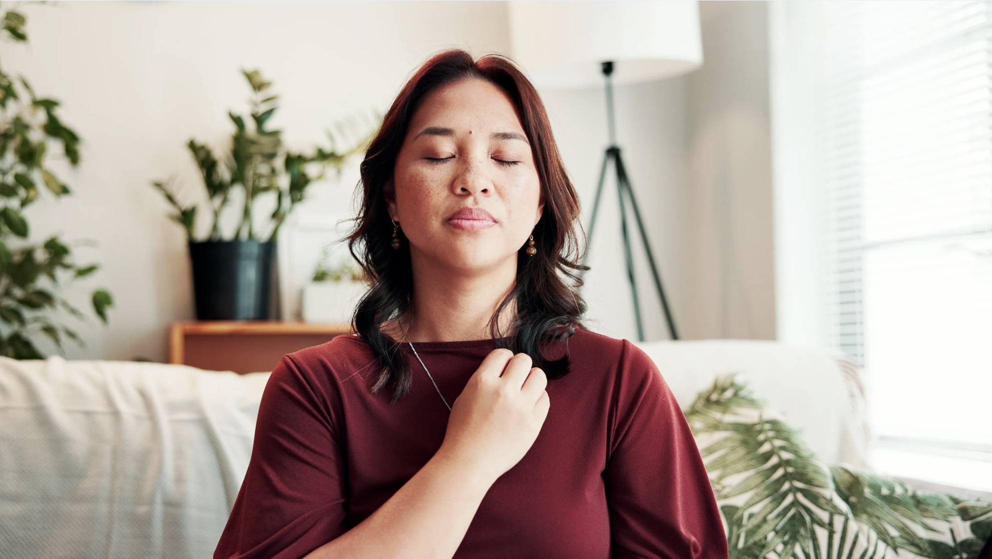 person with eyes closed, hand on chest, in a meditative state
